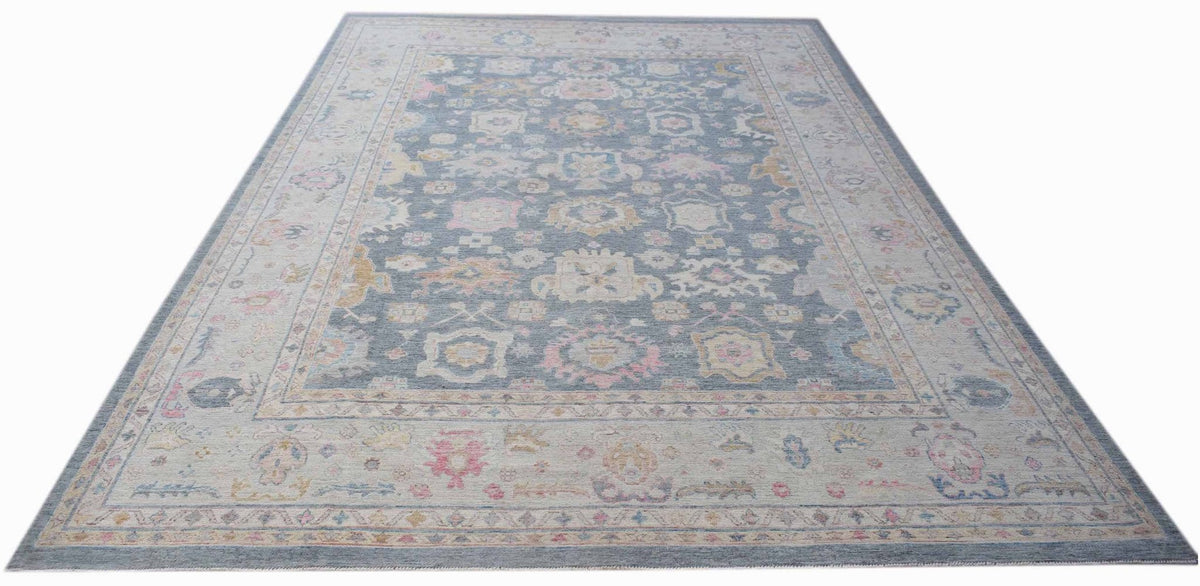 Hand-knotted Afghan wool rug featuring a large-scale Oushak floral design in muted blue, pink, and cream tones.