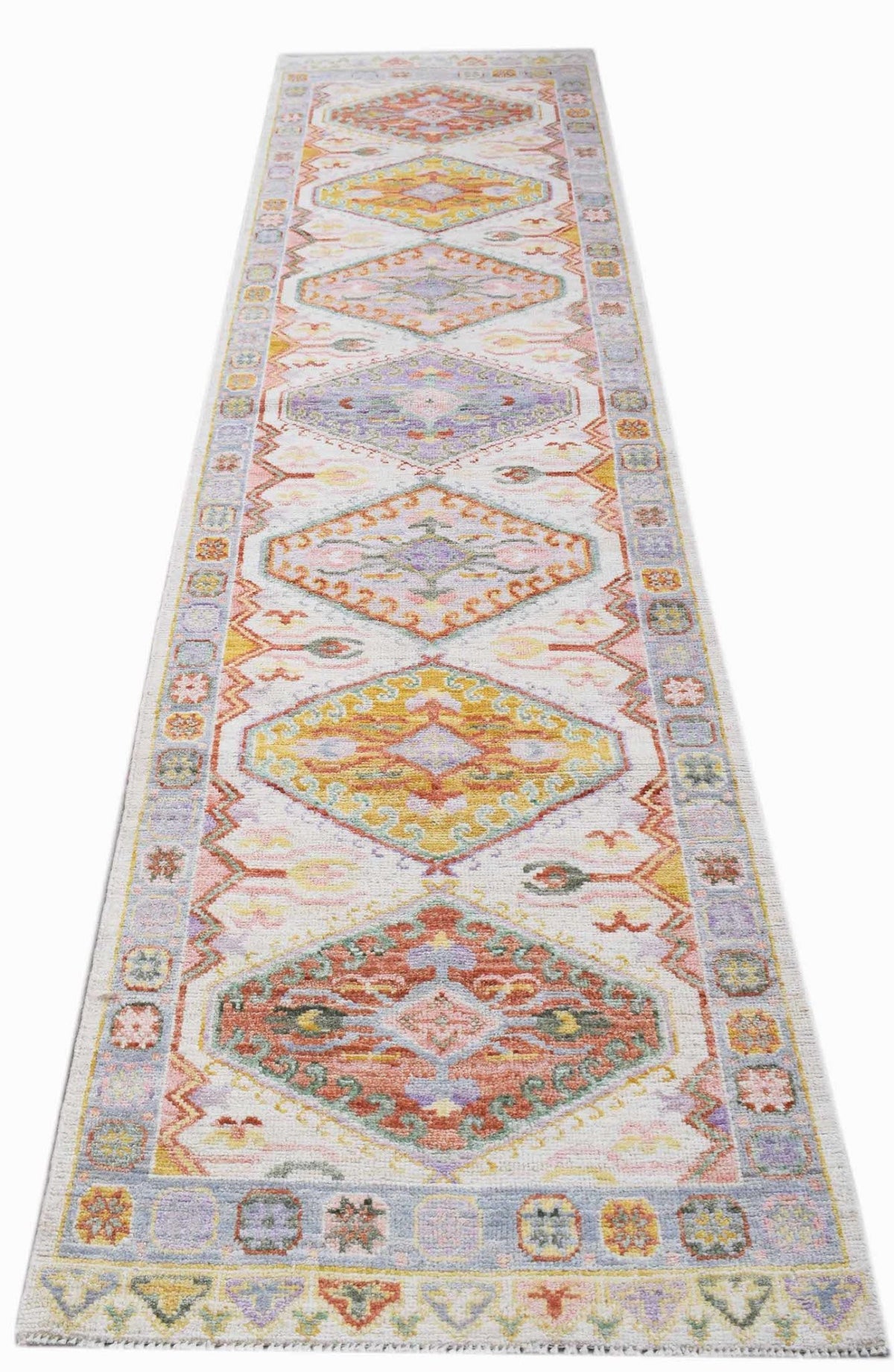 Hand-knotted transitional Oushak runner featuring colourful medallions and floral motifs on a light cream field.