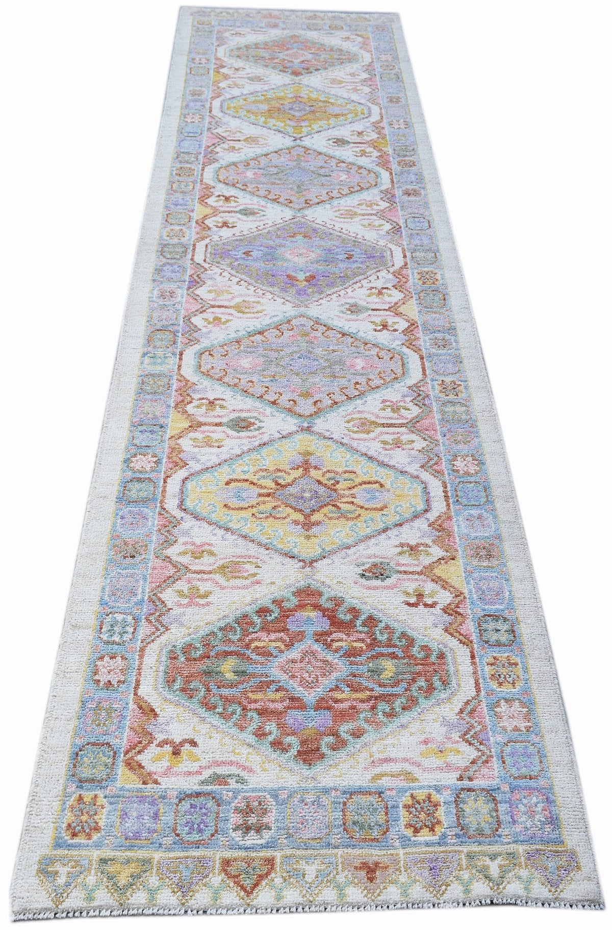 Hand-knotted transitional Oushak runner with a soft, multicoloured medallion pattern on a light cream field.