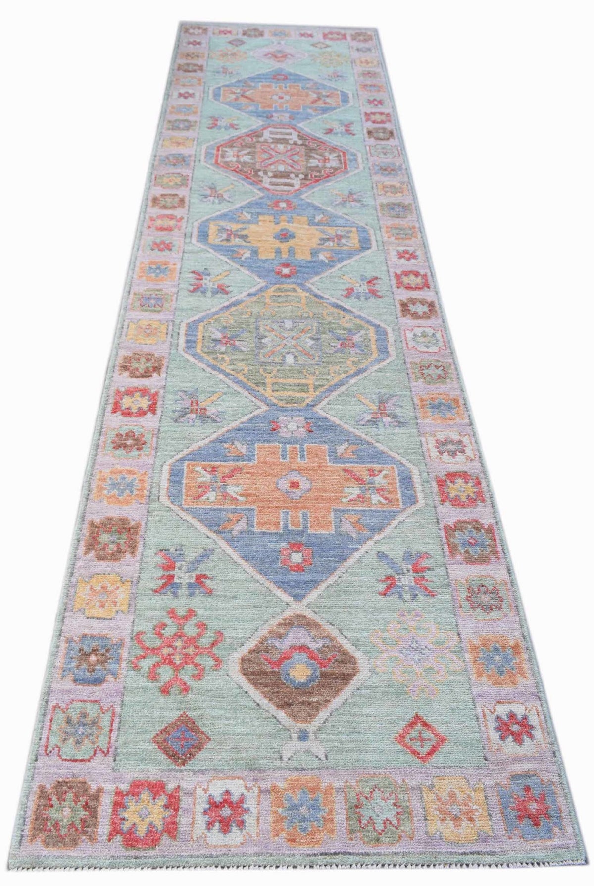 Hand-knotted transitional Oushak runner with soft medallions and palmettes in pastel blue, orange, and lilac tones.