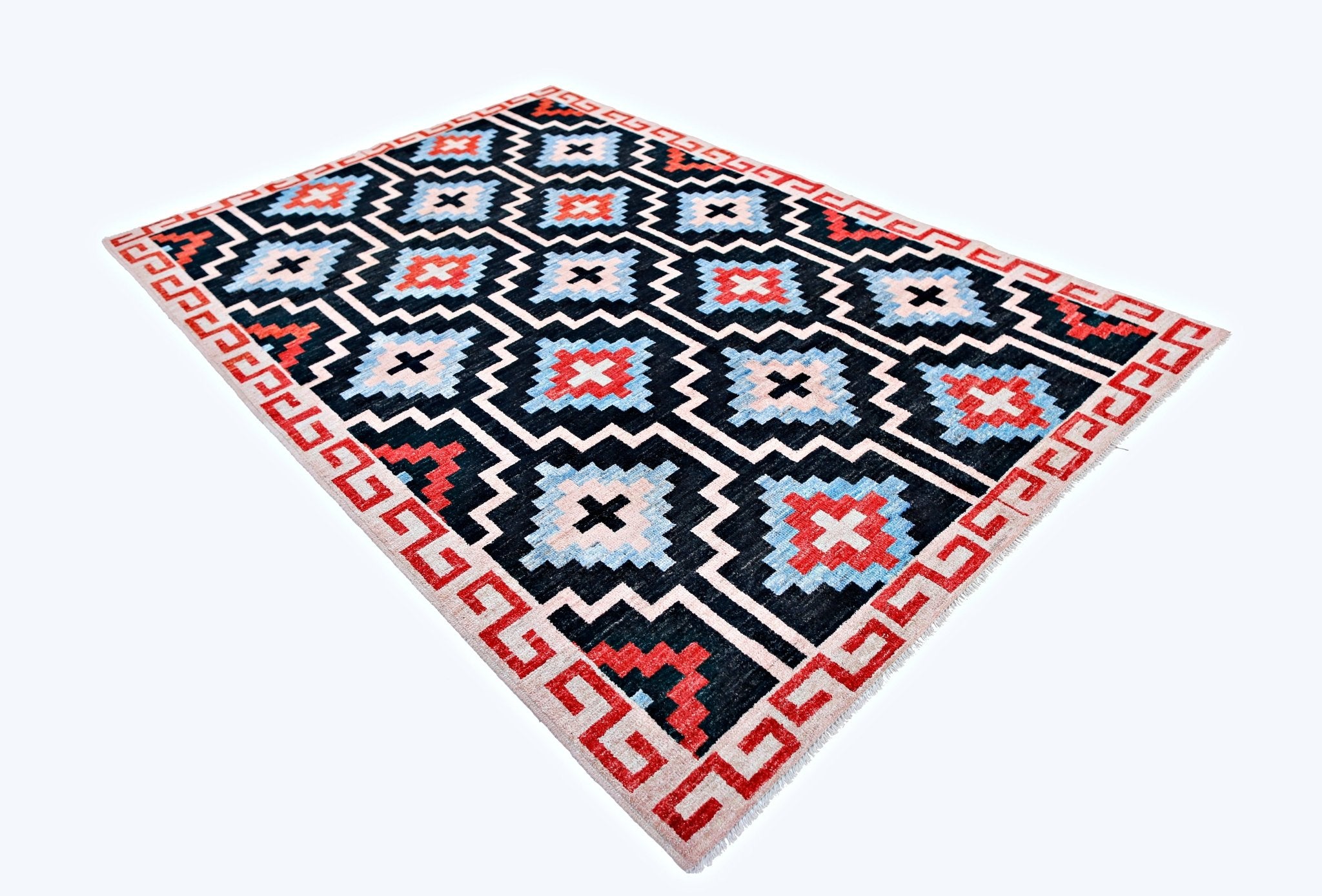 A handmade wool rug from Afghanistan featuring a geometric pattern in red, blue, and black.