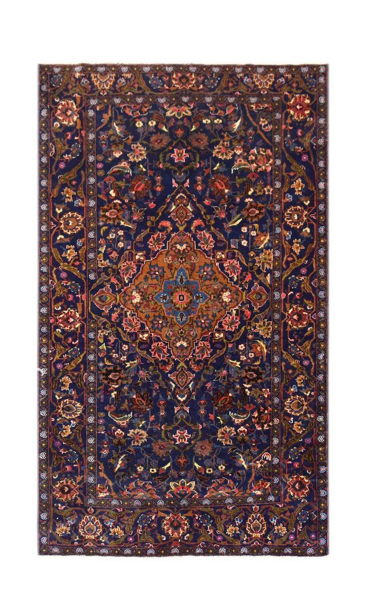 A rectangular vintage Afghan Baluch rug featuring a dark blue field with a central floral medallion.