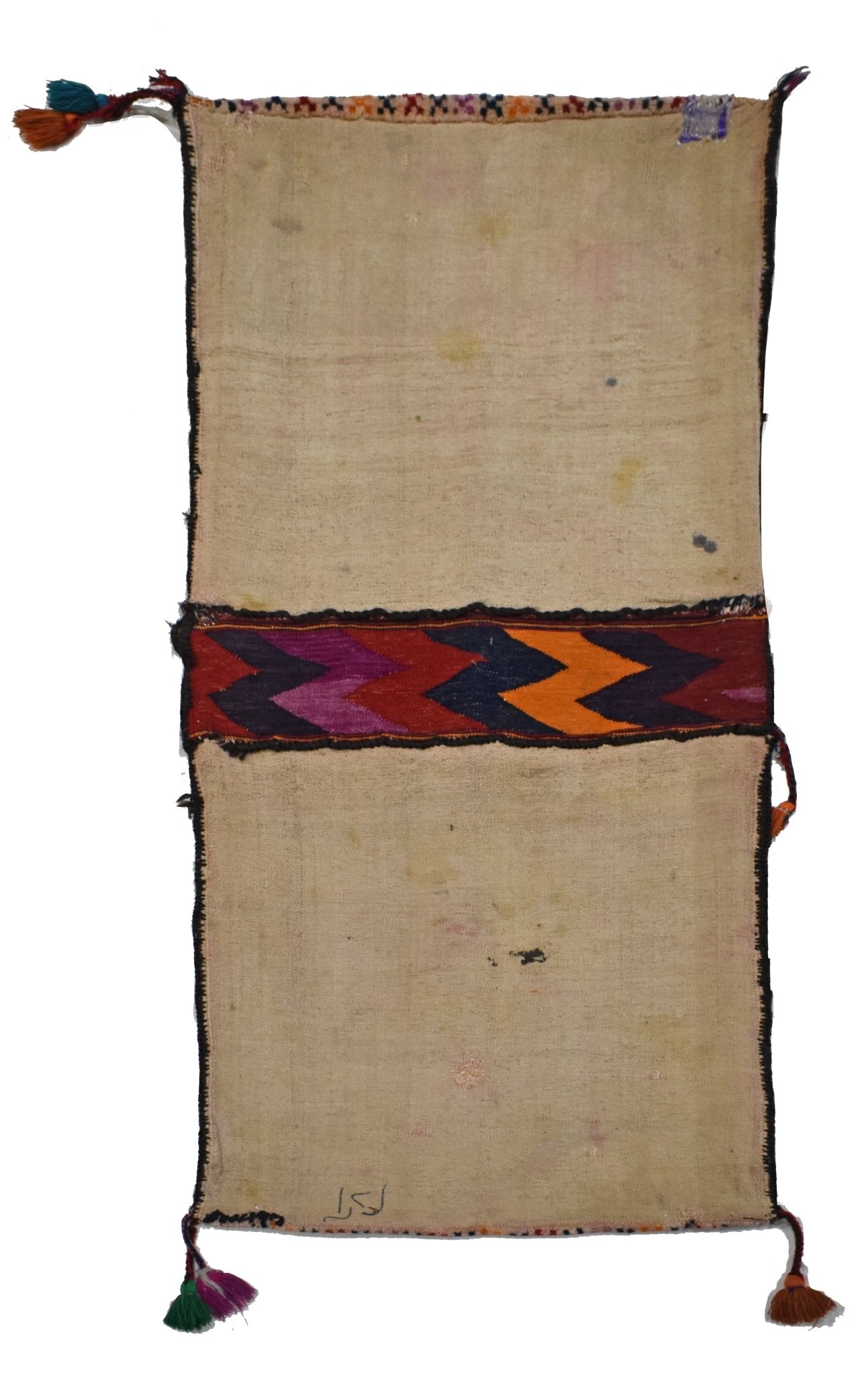 A vintage handmade Afghan wool saddle bag featuring a central chevron pattern and corner tassels.