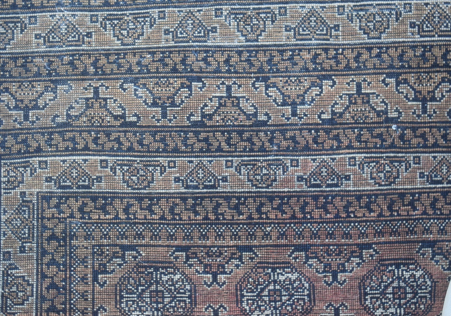 A vintage Afghan Turkmen rug featuring intricate geometric patterns in brown and black wool.