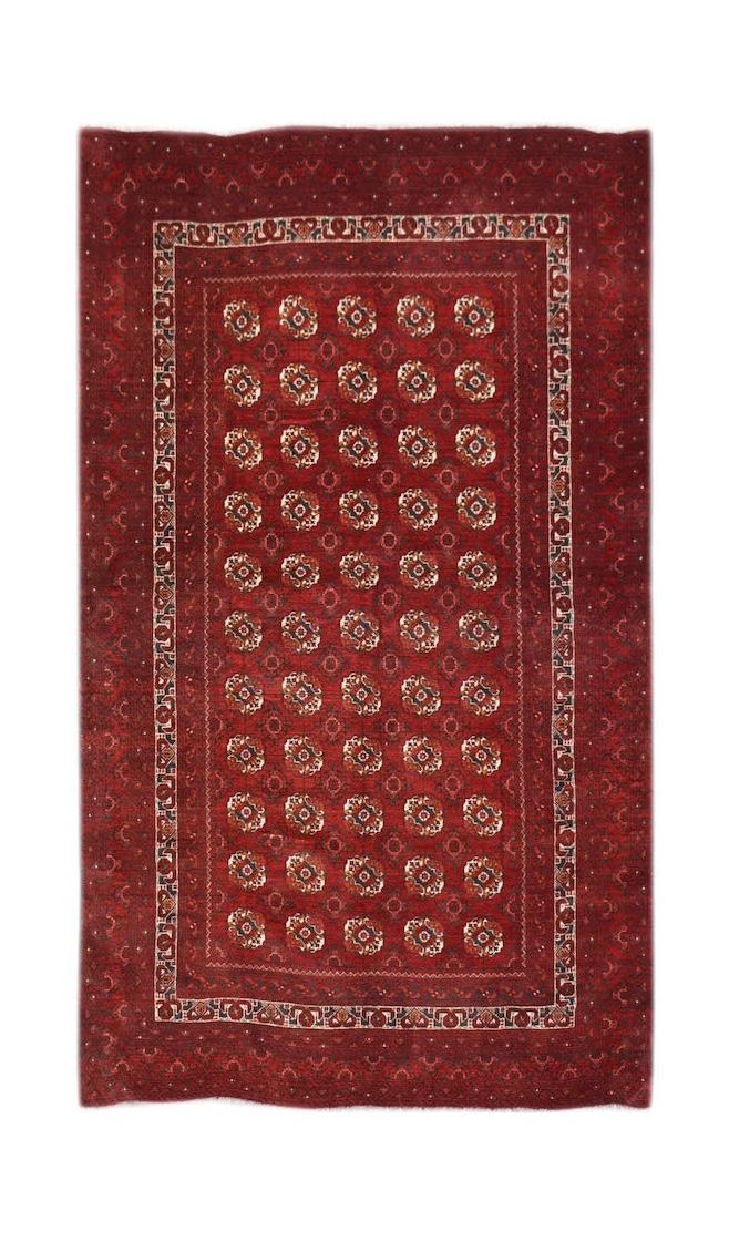 Vintage Afghan Turkmen rug with a red field and geometric patterns.