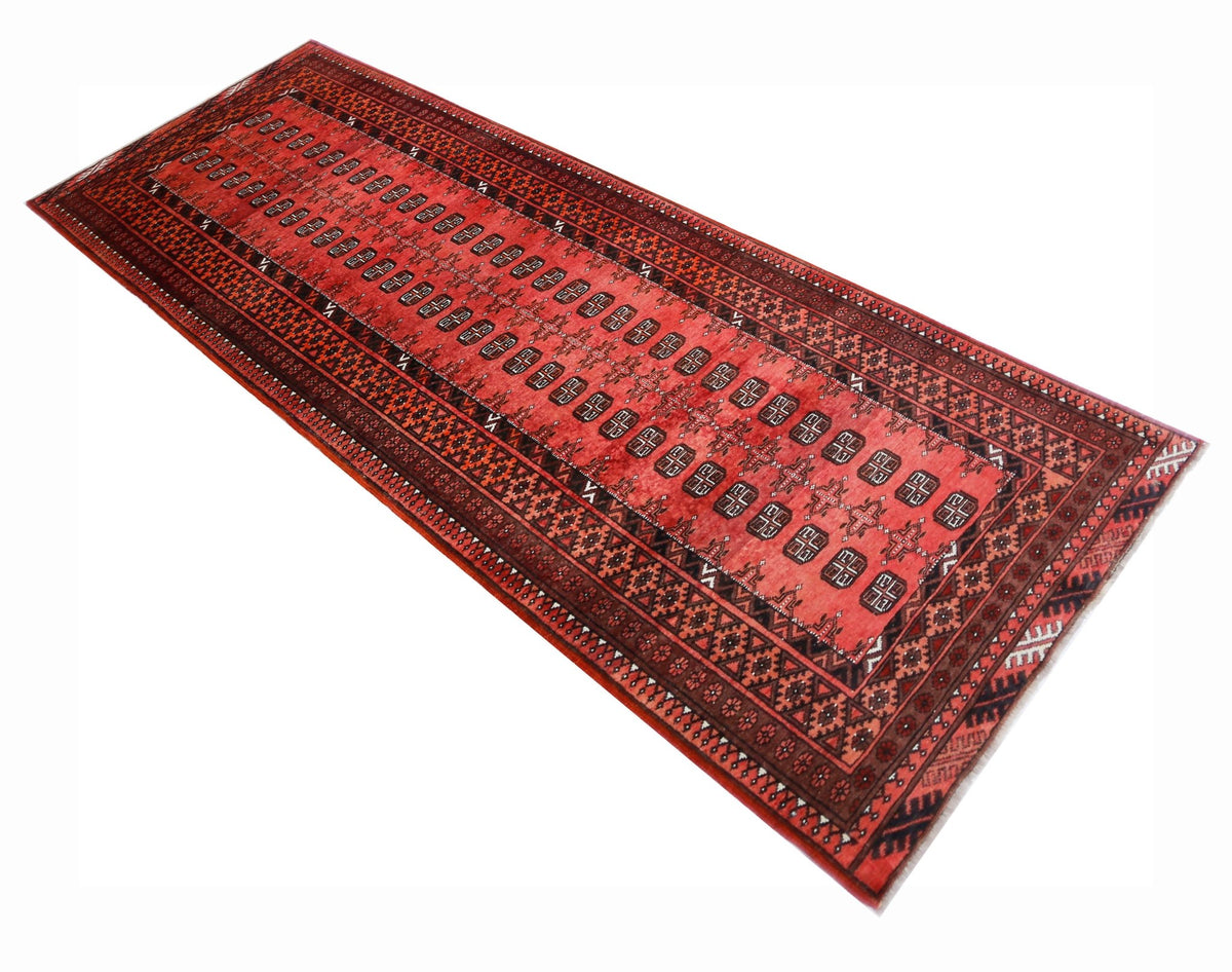 Hand-knotted Afghan Turkmen runner in deep red wool with repeating black and white gul medallions and geometric borders.