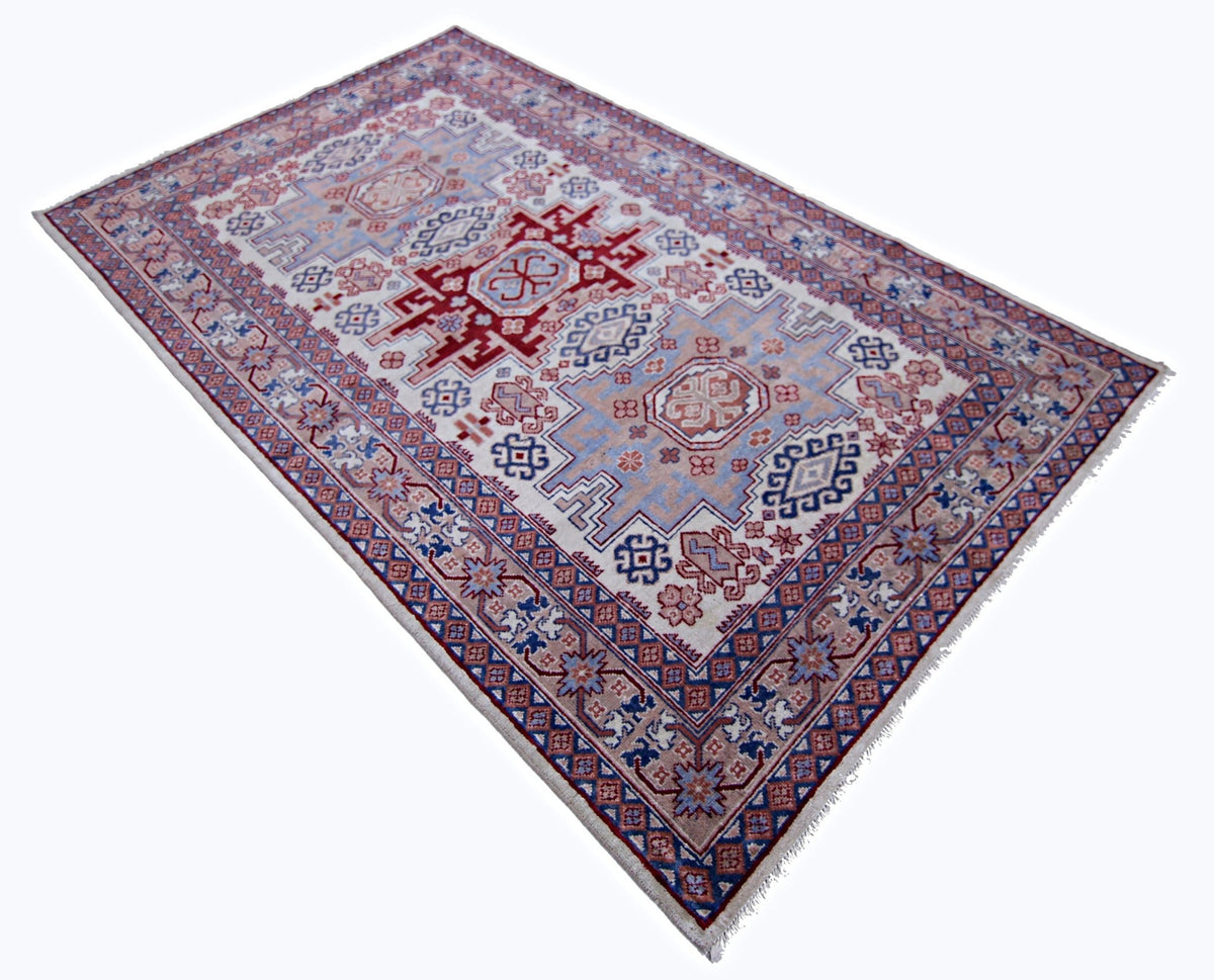 Vintage Caucasian Kazak rug featuring bold red, blue, and cream geometric medallions with a detailed patterned border.