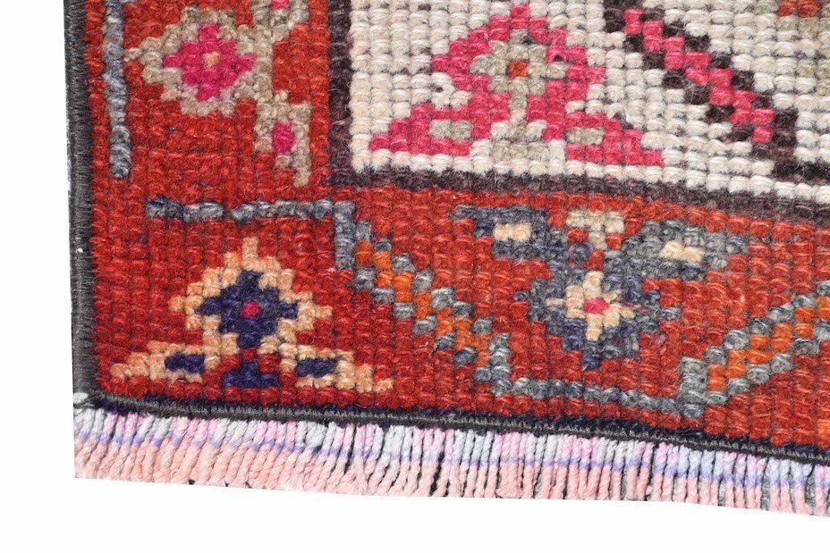 A vintage Kurdish Herki runner featuring tribal motifs in vibrant wool and nylon threads.