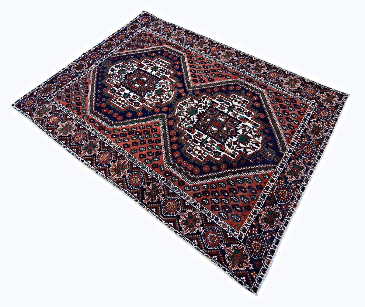 Vintage Persian Afshar rug with geometric medallions in deep red, navy, and cream hand-spun wool on a cotton foundation.