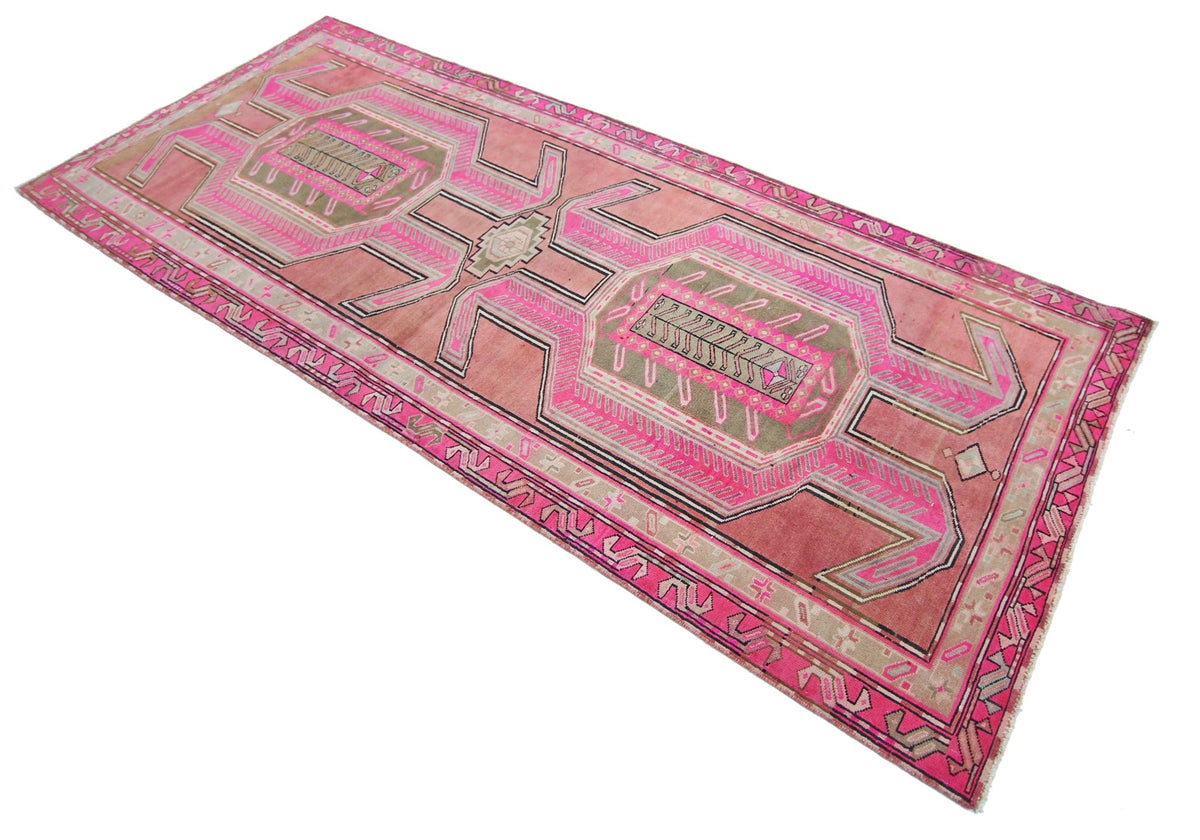 A vintage Persian Ardabil runner rug featuring geometric patterns in shades of pink and olive green.