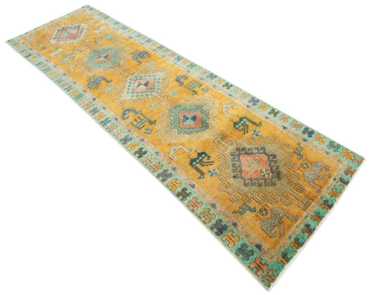 Vintage Persian Ardabil wool runner in golden yellow with geometric motifs, animal figures, and a decorative border.