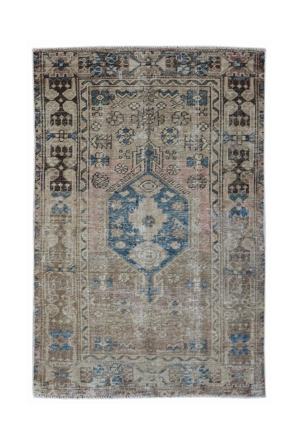 A vintage handwoven Persian Hamadan rug featuring a central blue medallion on a faded tan field.
