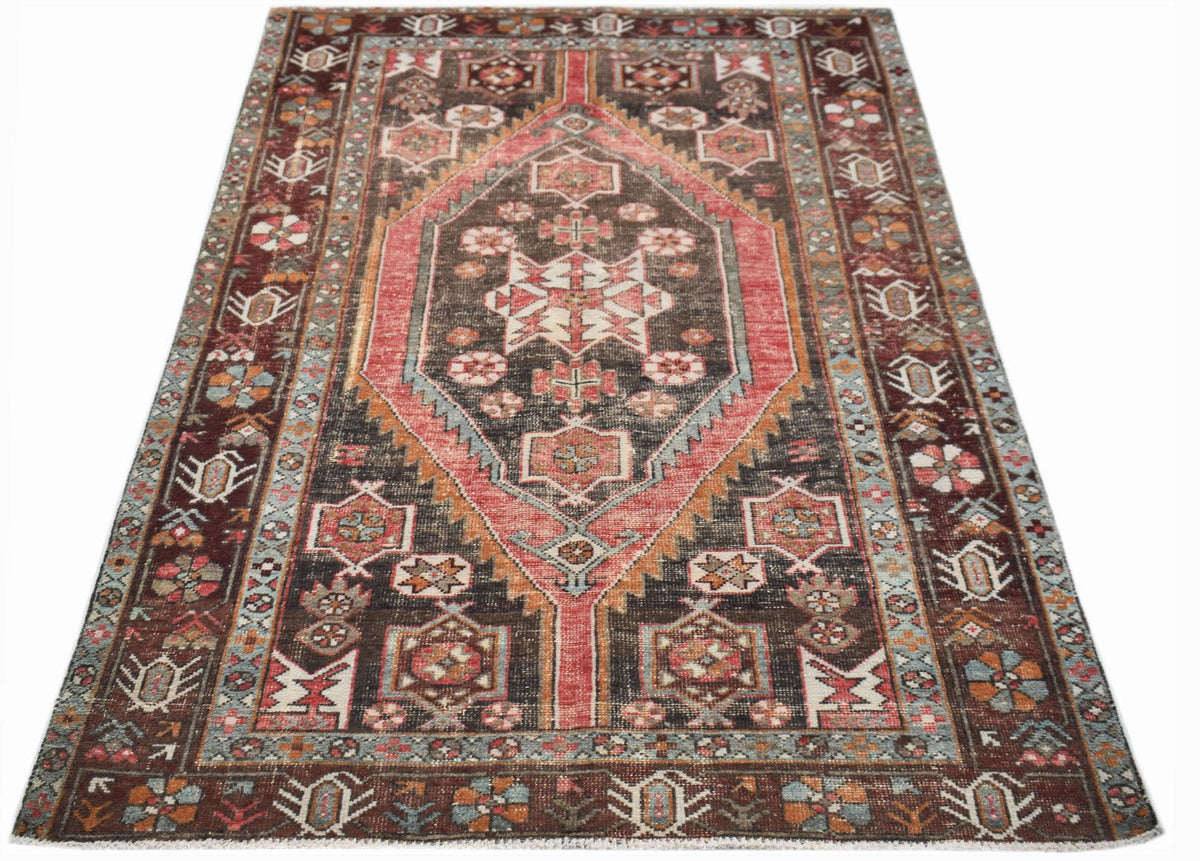 Hand-knotted Persian Hamadan rug featuring a large central diamond medallion in deep red, brown, and blue with tribal floral motifs.