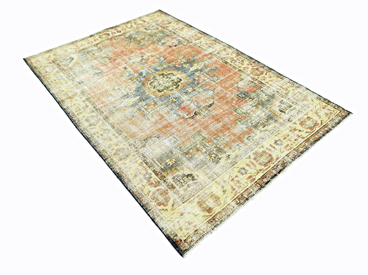 A vintage Persian rug featuring a faded orange field with a central blue medallion and floral border.