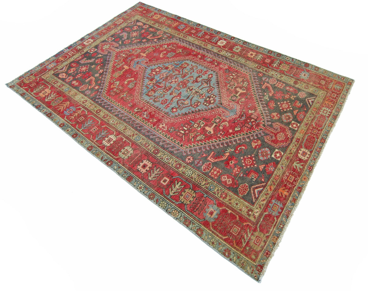 A vintage handmade Persian Hamadan rug featuring a central blue medallion on a red field.