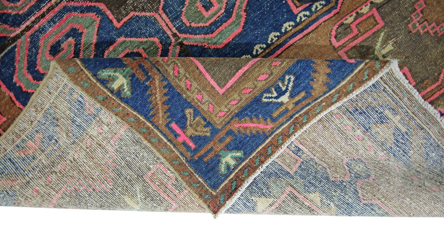 A vintage Persian Hamadan rug featuring a geometric pattern in blue, brown, and pink wool.