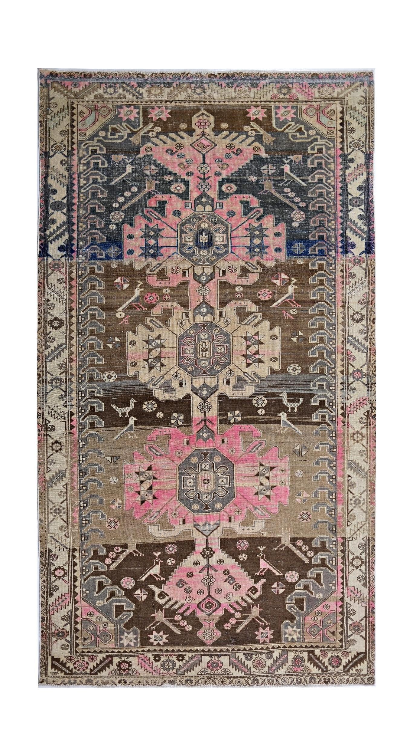 A vintage Persian Hamadan rug featuring geometric floral medallions and bird motifs in pink and brown.