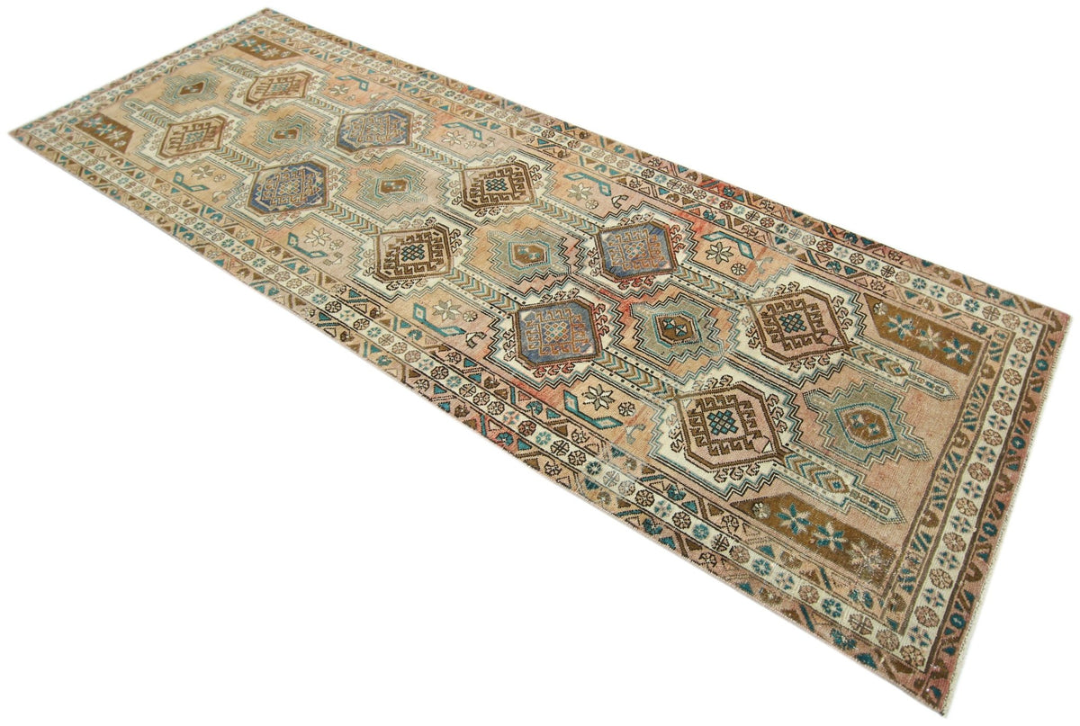 Hand-knotted vintage Persian Hamadan runner featuring repeating geometric medallions in muted earth tones and blue.