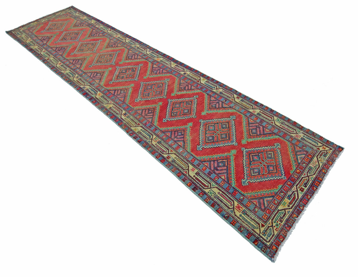 A vintage Persian Hamadan runner featuring a red field with repeating geometric diamond motifs.