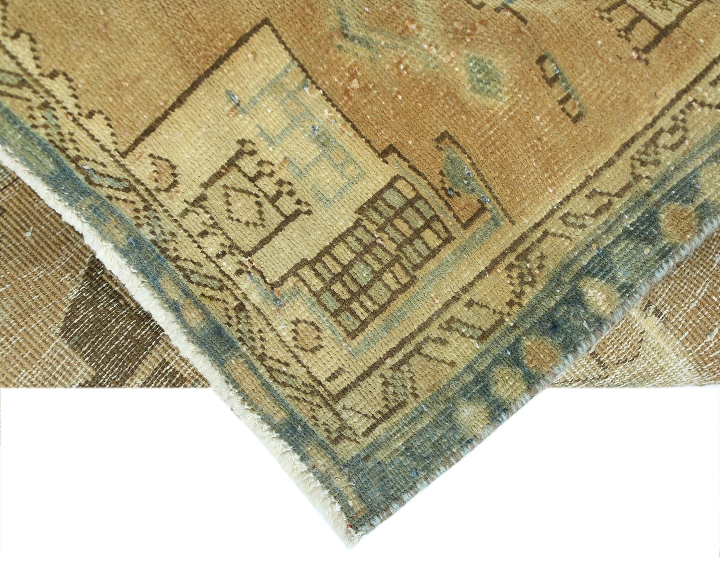 A corner view of a vintage Persian Hamadan runner featuring geometric patterns in tan and blue.