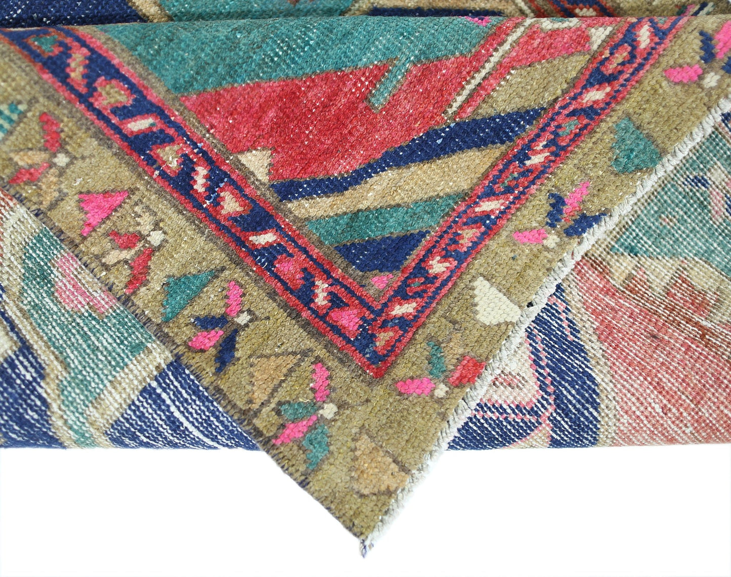 A corner of a vintage Persian Hamadan runner featuring geometric patterns in red, blue, and green.