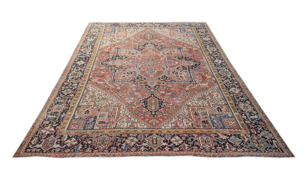 A vintage handwoven Persian Heriz rug featuring a geometric medallion on a terracotta field.