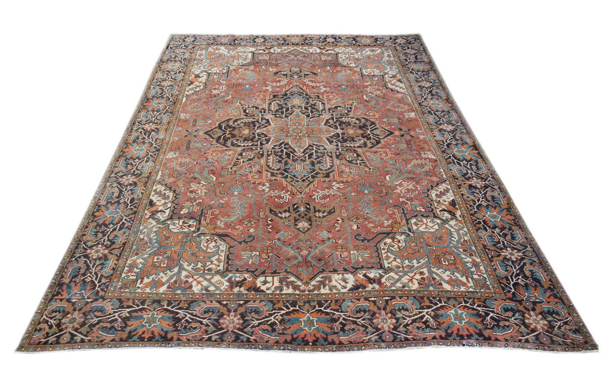 A vintage handwoven Persian Heriz rug featuring a central medallion on a rust-red field.