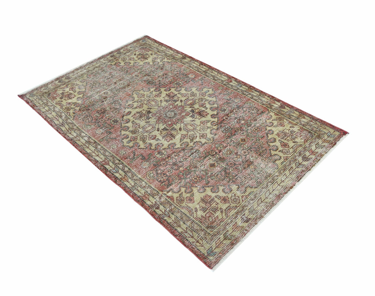 A vintage Persian rug featuring a traditional medallion pattern in faded red and beige tones.