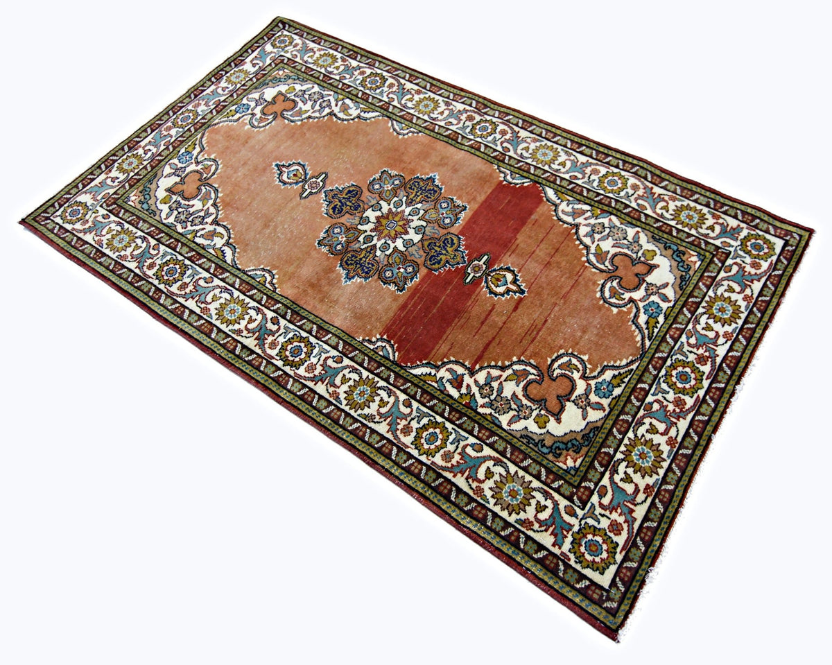 Hand-knotted vintage Persian Kashan rug with a terracotta field, central floral medallion, and intricate cream border.