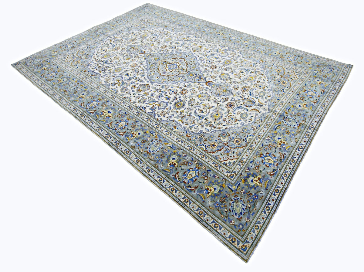 Hand-knotted Persian Kashan rug featuring a central medallion and intricate floral patterns in shades of blue and cream.