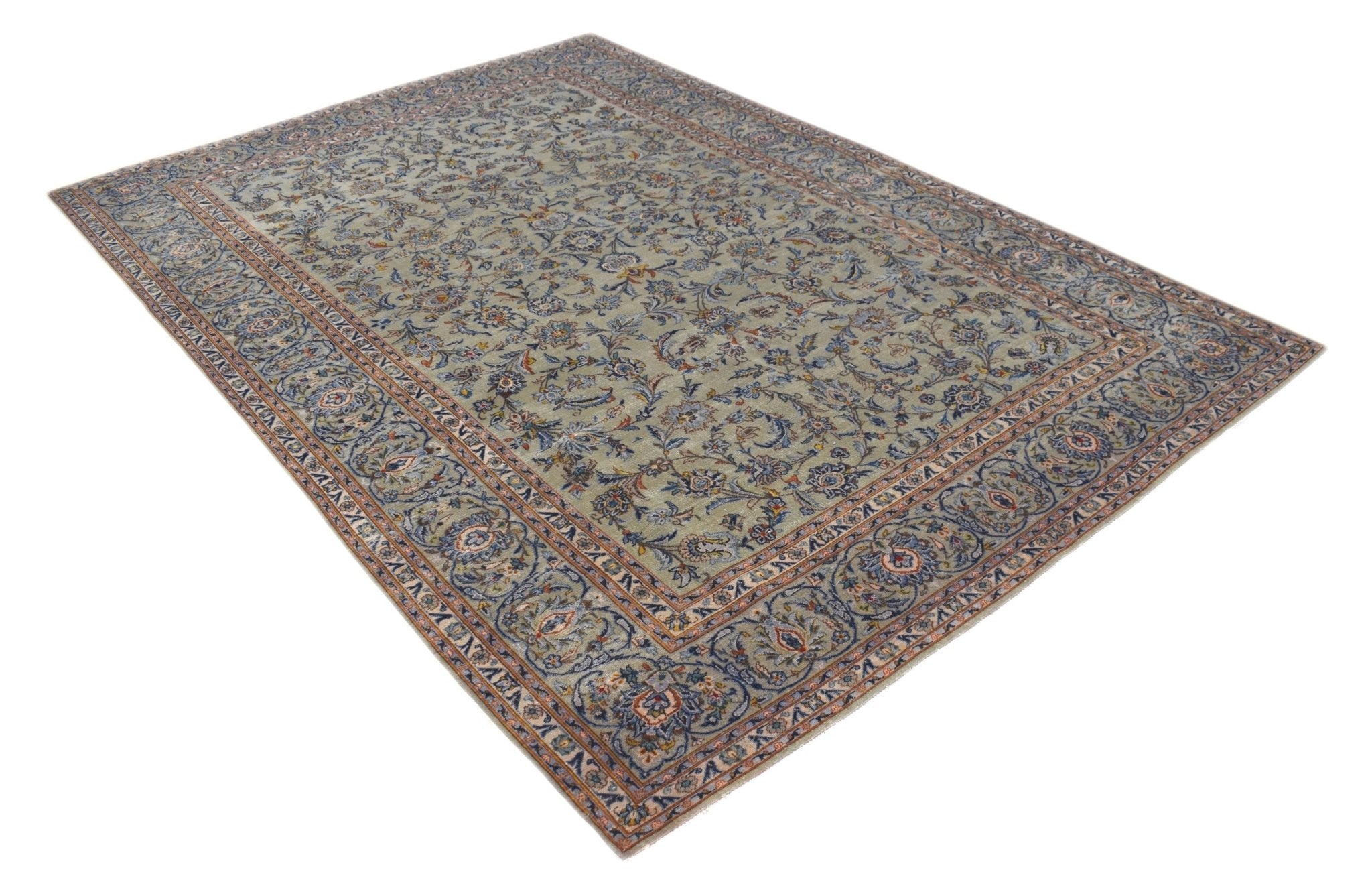 A vintage handwoven Persian Kashan rug featuring intricate floral patterns in blue and beige tones.