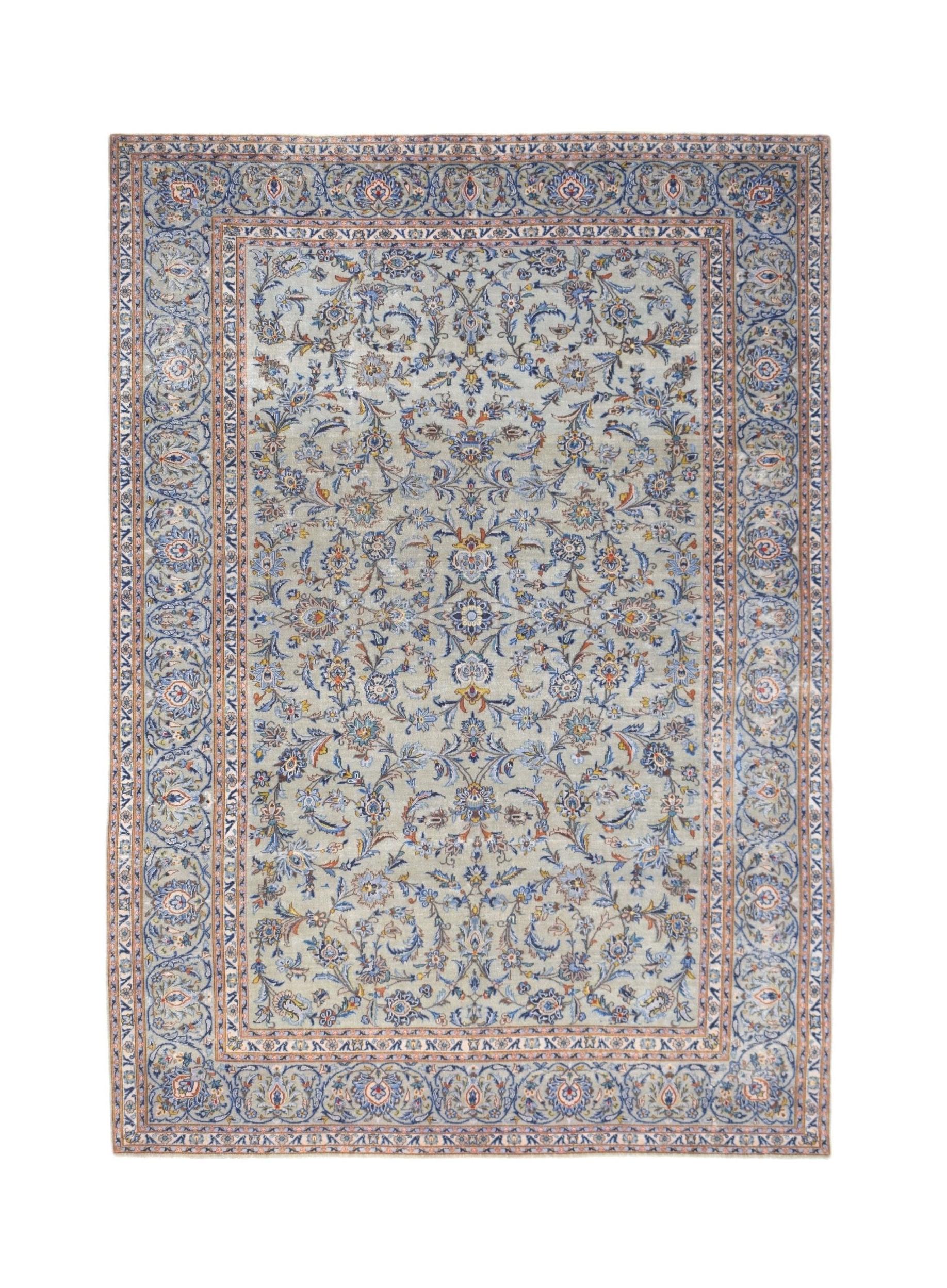A vintage handwoven Persian Kashan rug featuring intricate floral patterns in blue and cream tones.