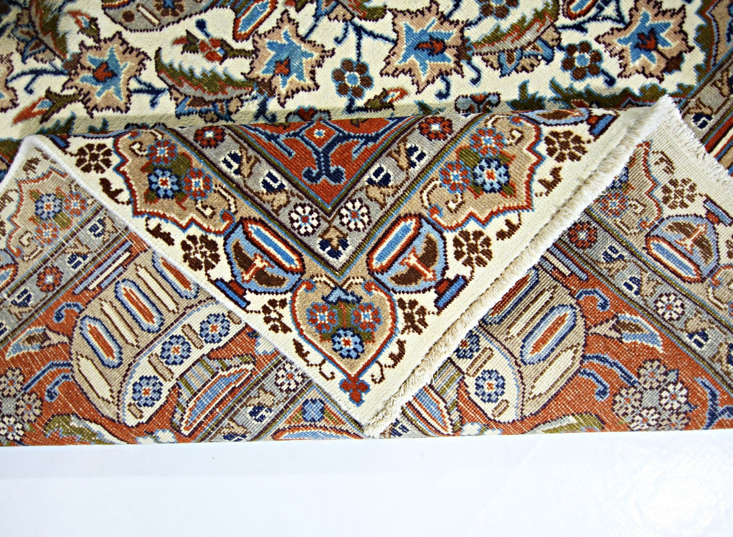 A vintage Persian Kashmar rug with intricate floral patterns in blue, red, and cream tones.