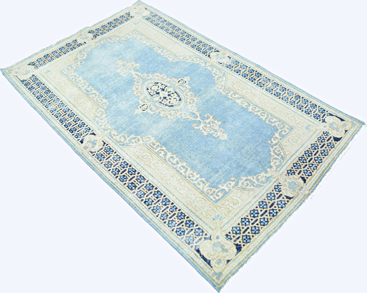 Vintage hand-knotted Persian Kerman rug in light blue and cream with an intricate central medallion and floral border.