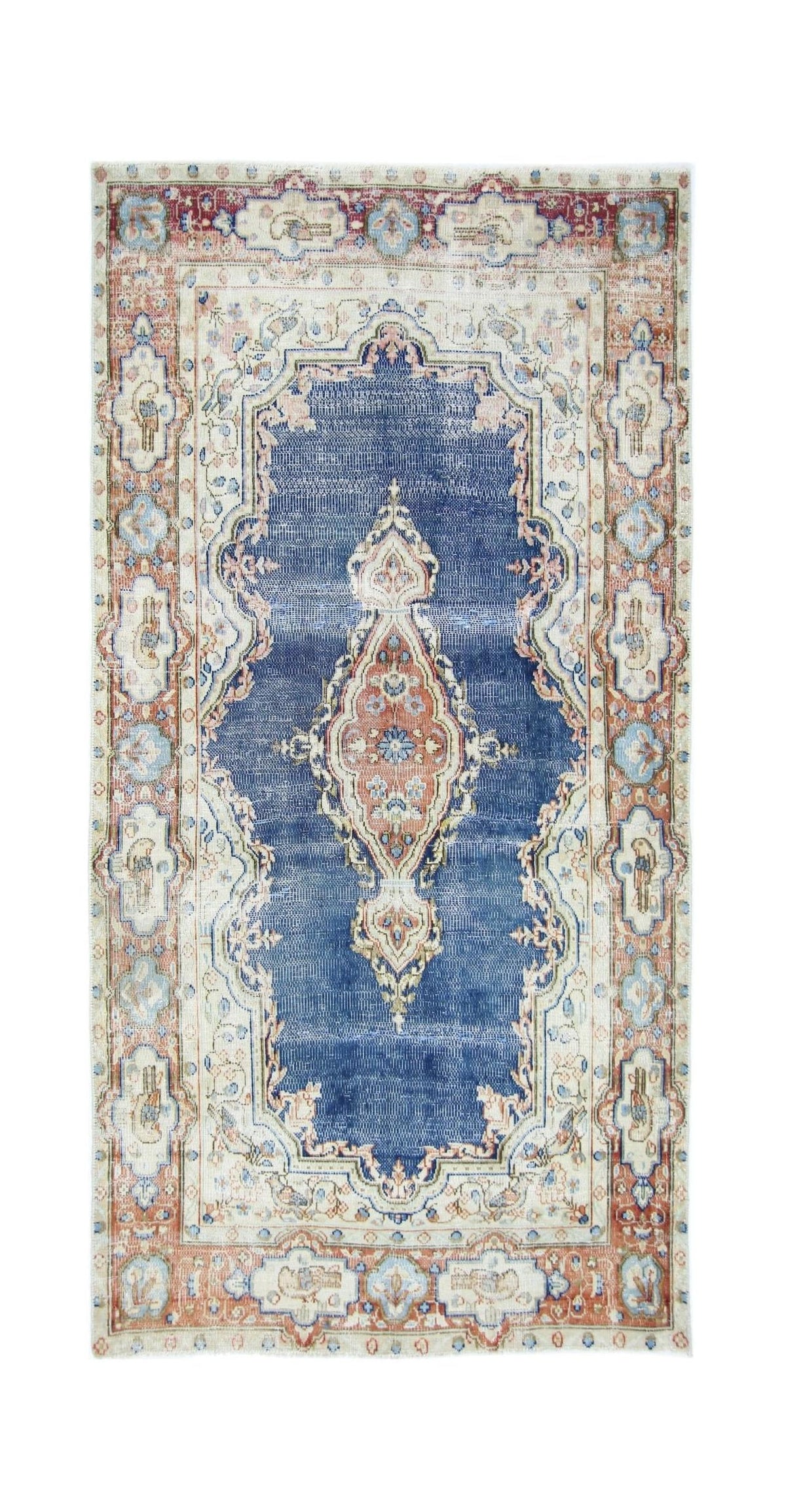 Vintage Persian Kerman rug featuring a central medallion with intricate floral patterns in blue, cream, and terracotta tones.