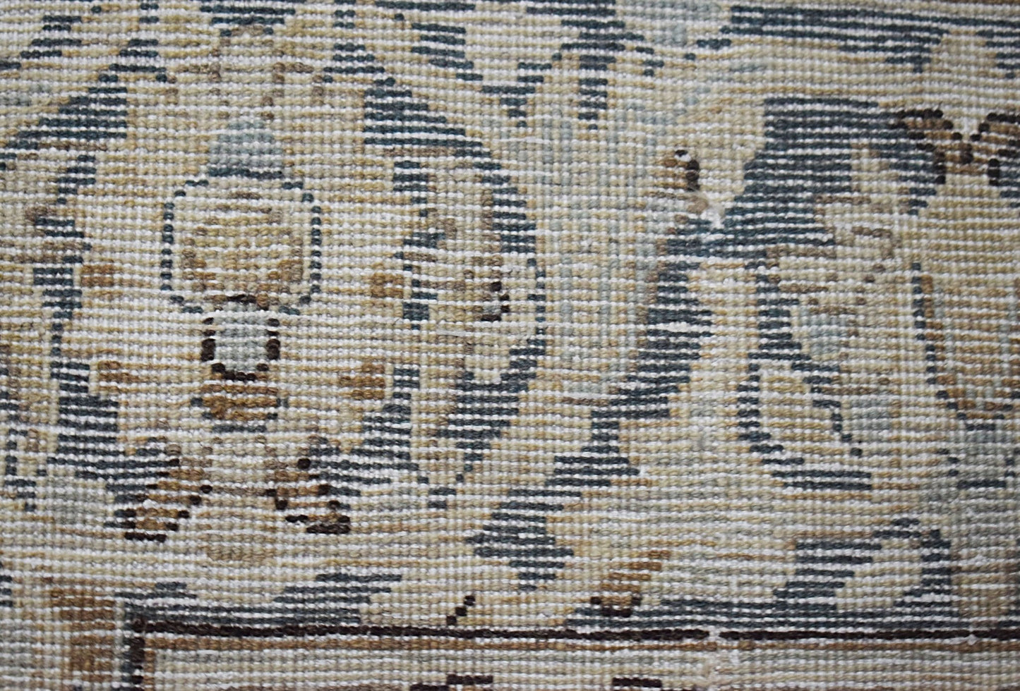 A close-up view of a vintage Persian Kerman rug featuring intricate floral and medallion patterns.