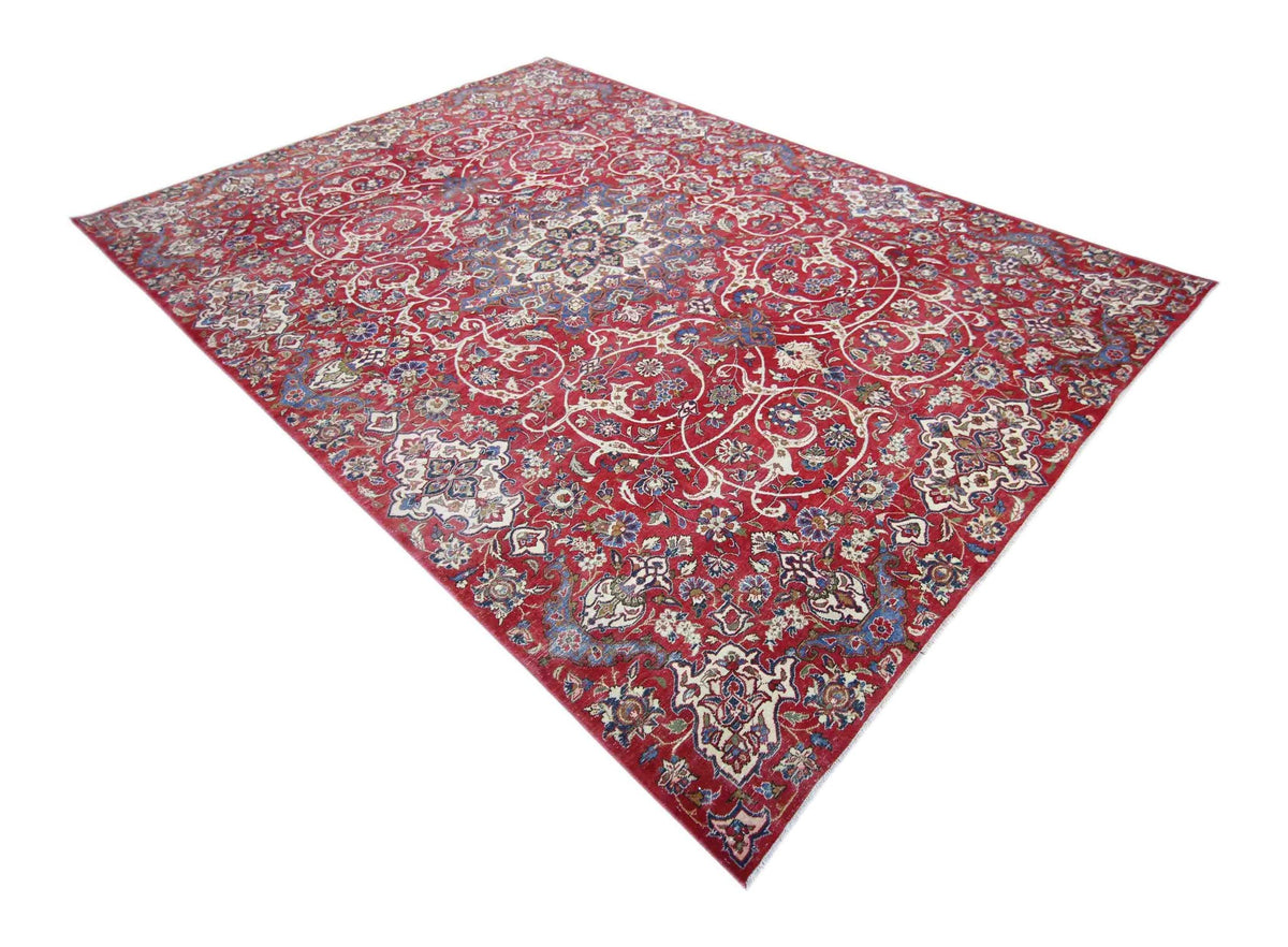 Vintage Persian Kerman wool rug featuring an intricate red floral field and central medallion on a white background.