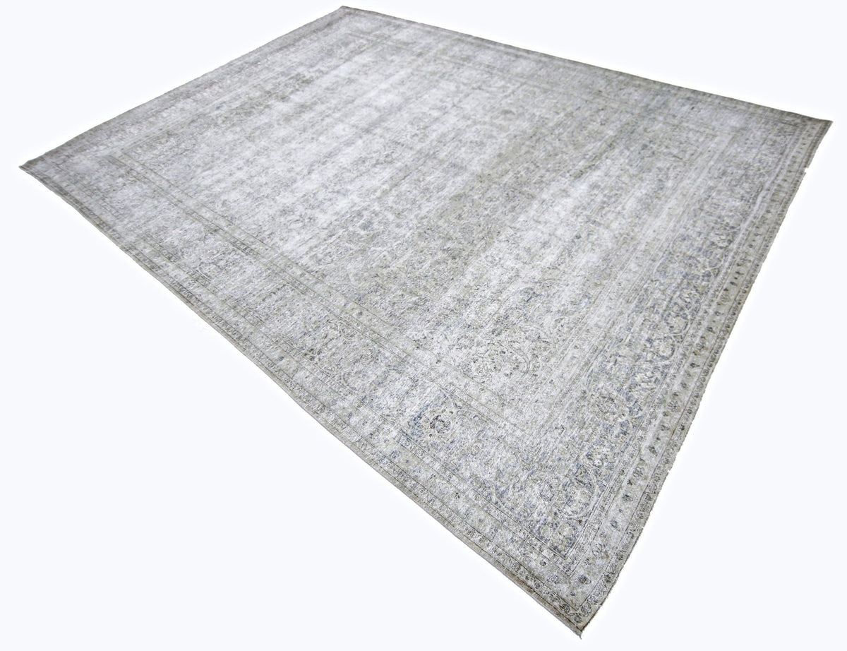 Vintage Persian Kerman rug with a faded grey and blue intricate floral pattern and a low-pile wool finish.