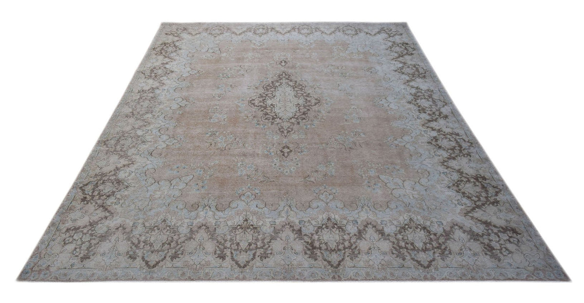 A vintage Persian Kerman rug featuring a central medallion and intricate floral patterns in beige.