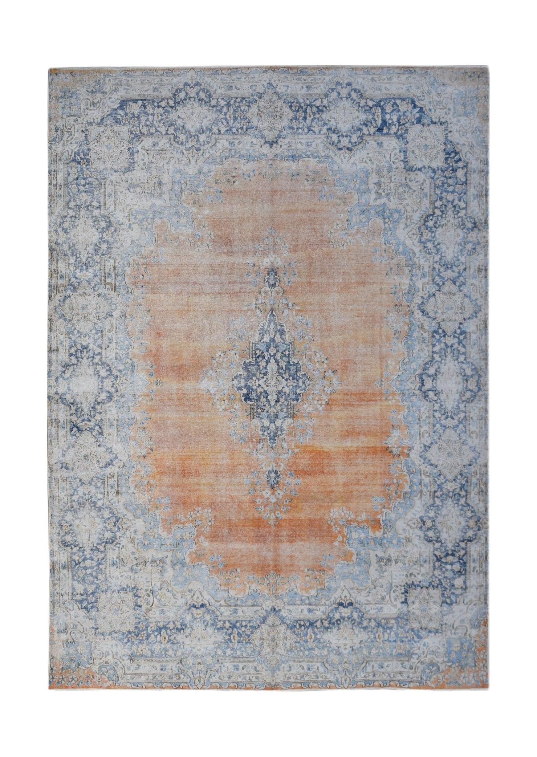 A vintage Persian Kerman rug featuring a central blue medallion on an orange field with floral motifs.