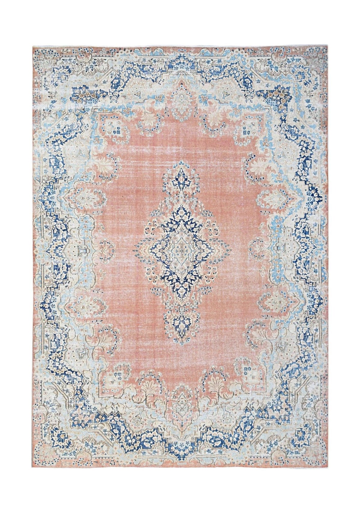 A vintage Persian Kerman rug featuring a central medallion and floral motifs in pink and blue.