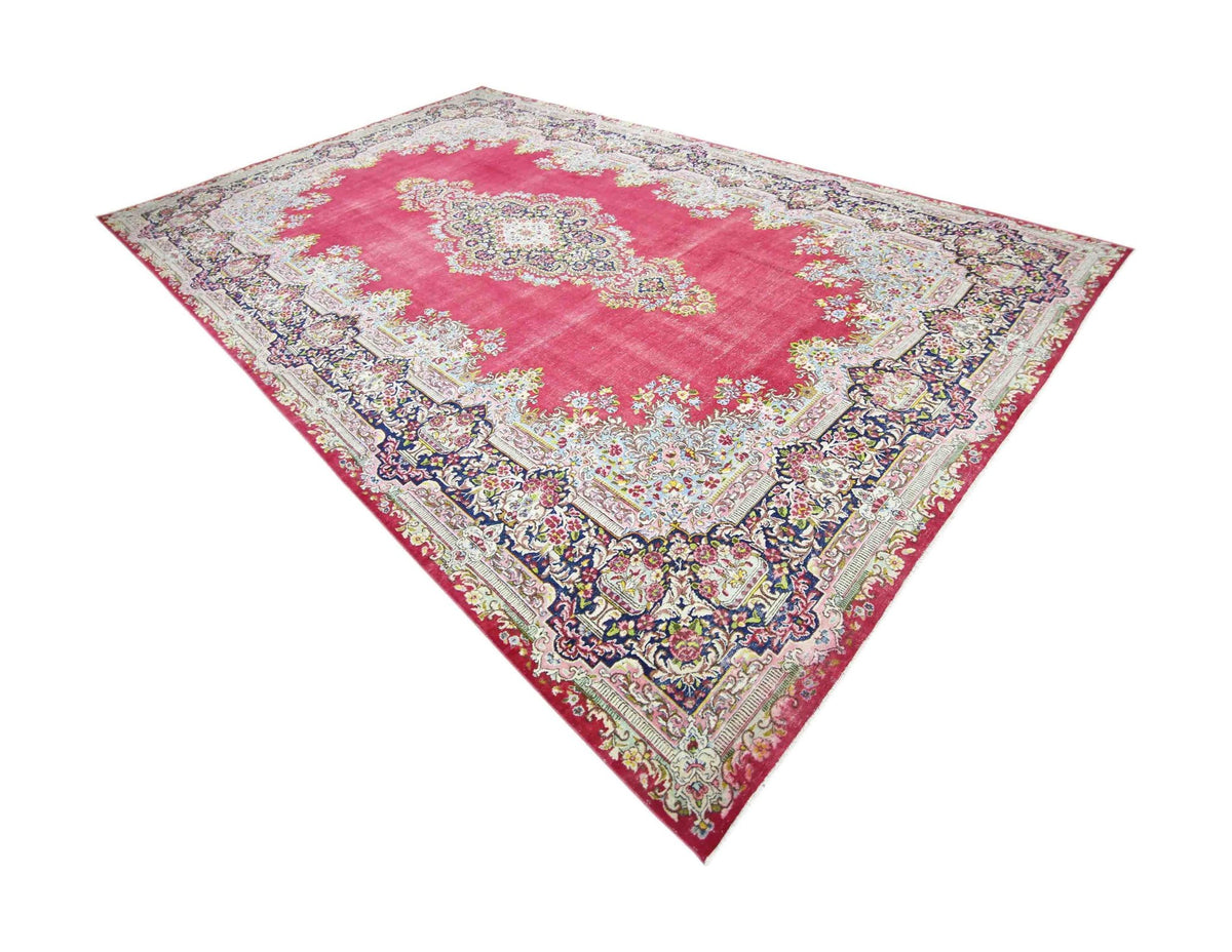 Vintage Persian Kerman rug with a vibrant pink field, intricate floral patterns, and a detailed central medallion.