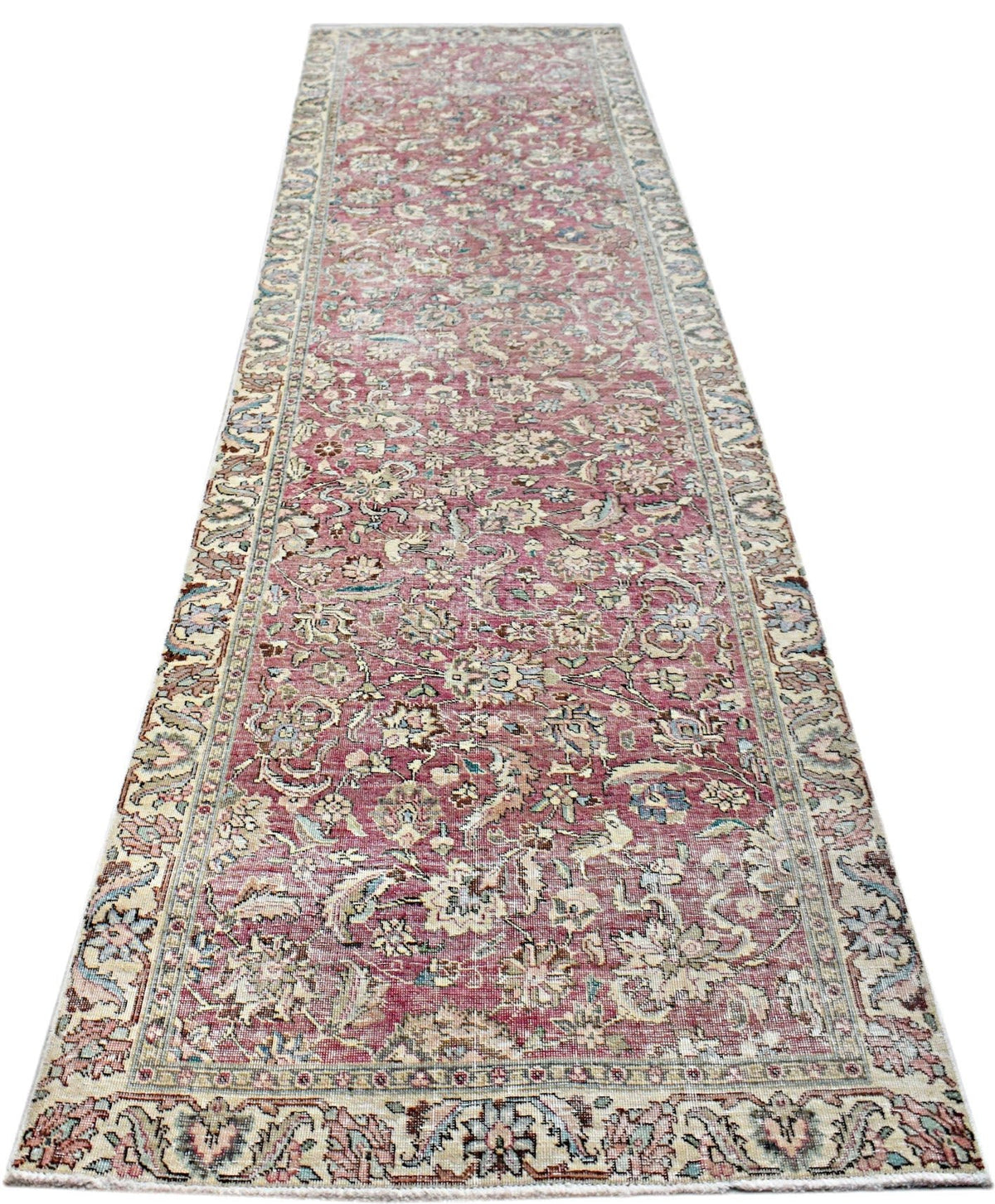 Vintage Persian Kerman runner featuring an intricate floral vine pattern in soft pink, blue, and cream tones.