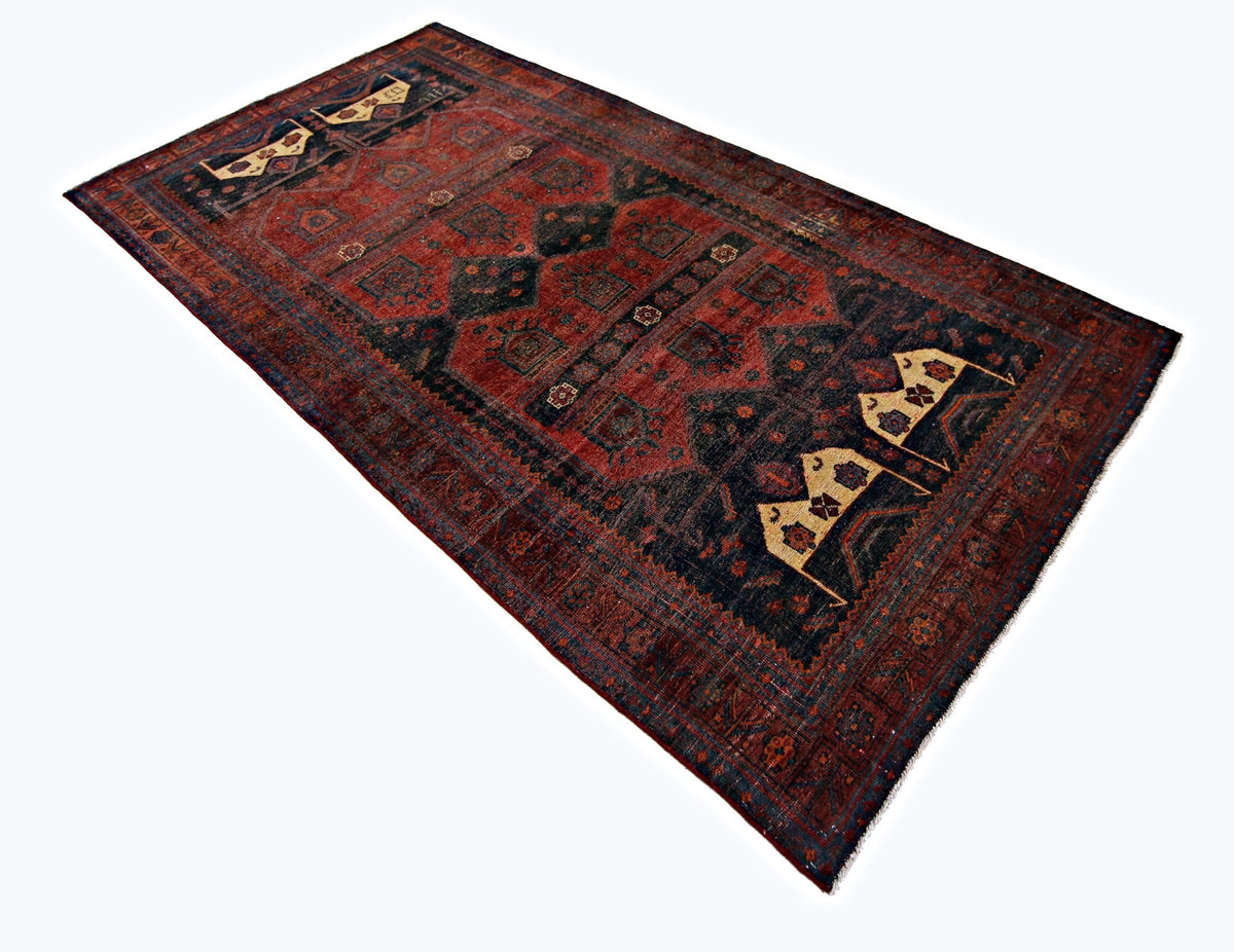 Vintage hand-knotted Persian Koliai rug in deep red and navy with geometric tribal motifs and a short fringe.