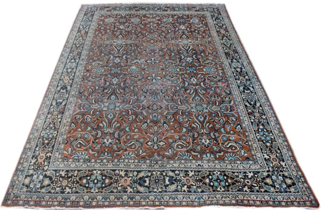 A vintage Persian Lori rug featuring a detailed floral pattern in rust, blue, and cream tones.
