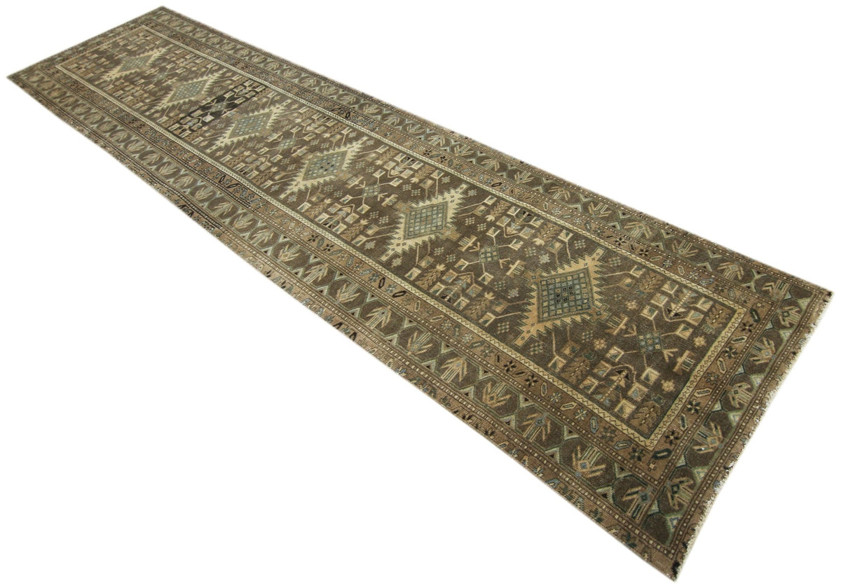 Vintage Persian Malayer runner with intricate geometric medallions and floral motifs in muted earth tones and indigo.