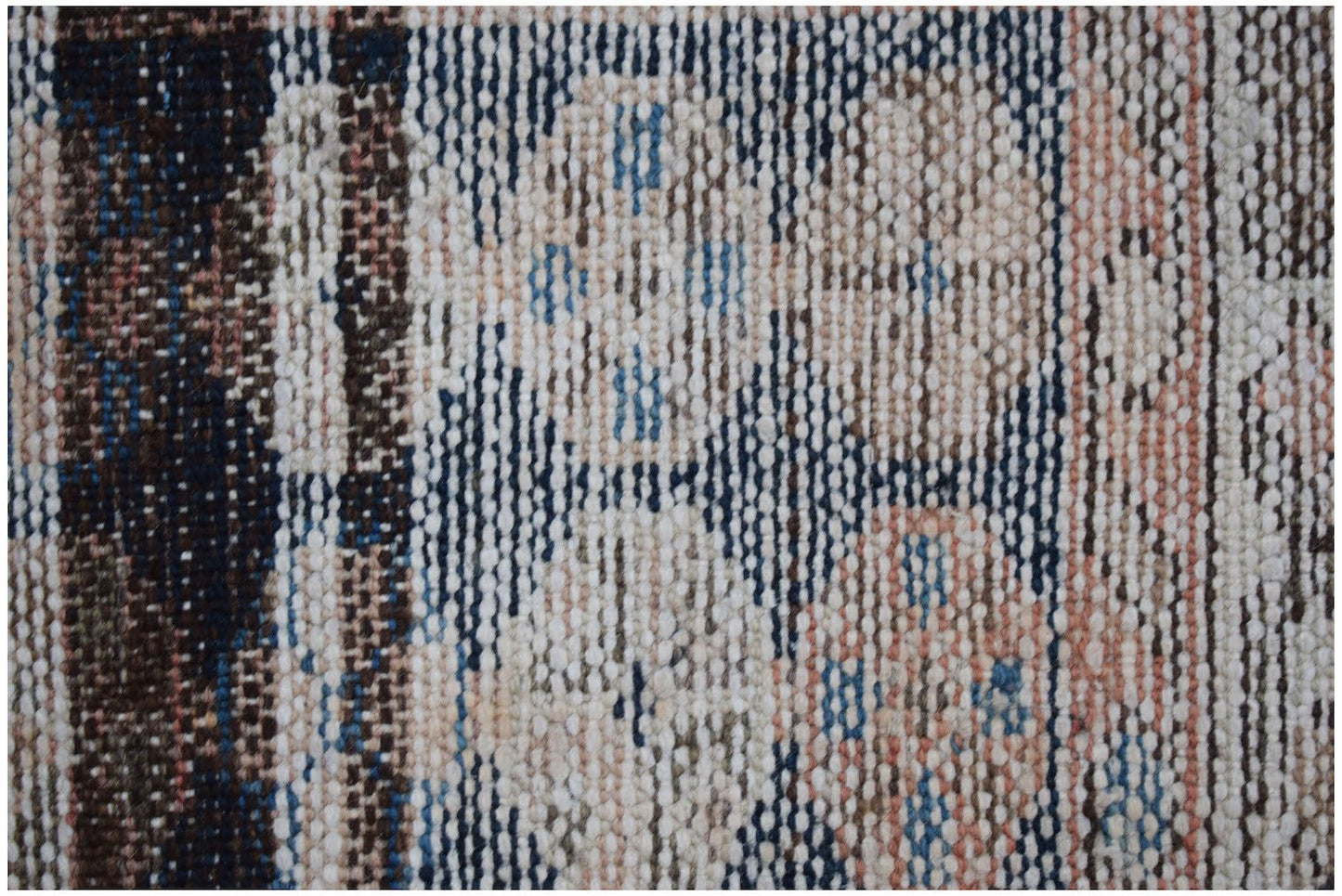 A close-up of a vintage Persian Mazlaghan rug featuring geometric patterns in blue, tan, and cream.