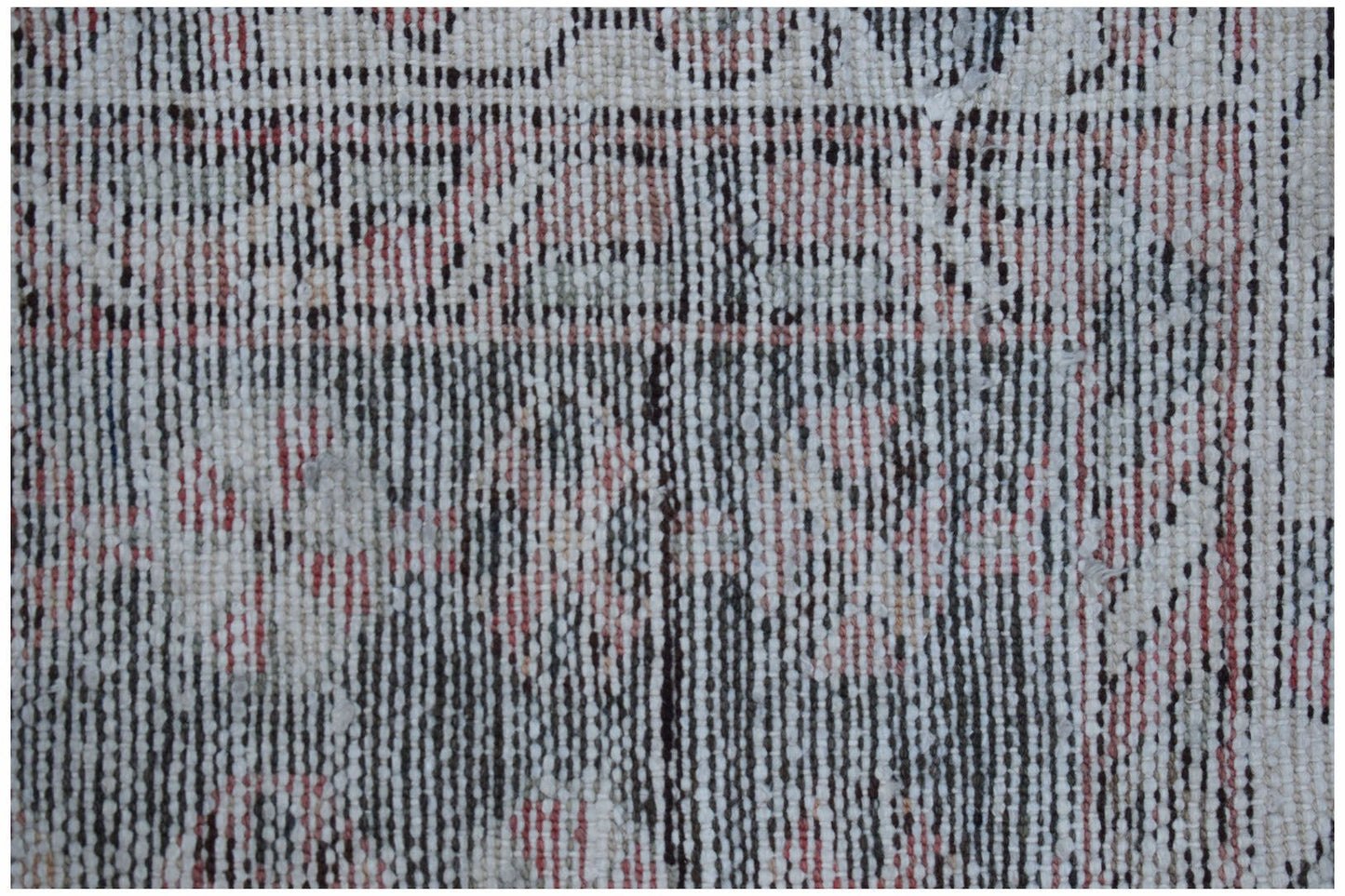 A close-up view of a vintage Persian Mazlaghan rug featuring a faded geometric pattern in wool.