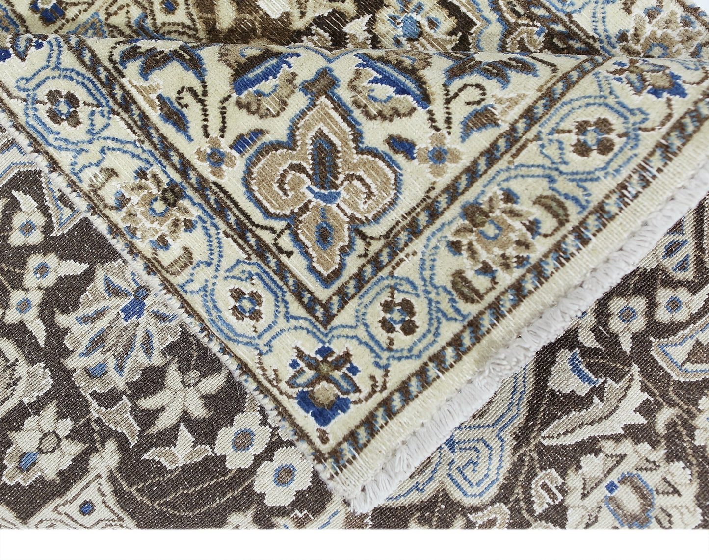 A vintage Persian Nain rug featuring intricate floral patterns in shades of blue, brown, and cream.