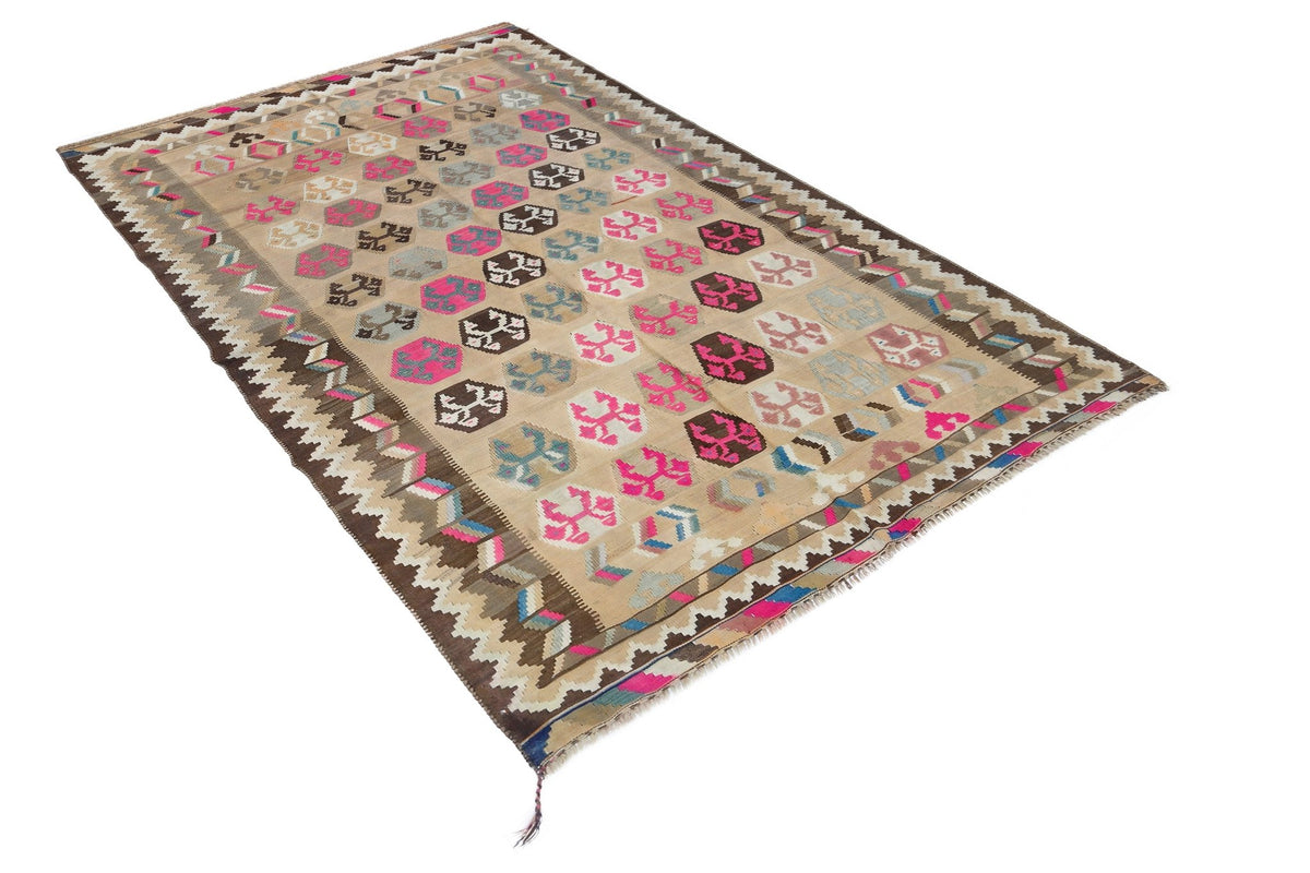 Handwoven vintage Persian Qashqai kilim with a beige field, geometric hexagonal motifs in pink and brown, and a fringed edge.
